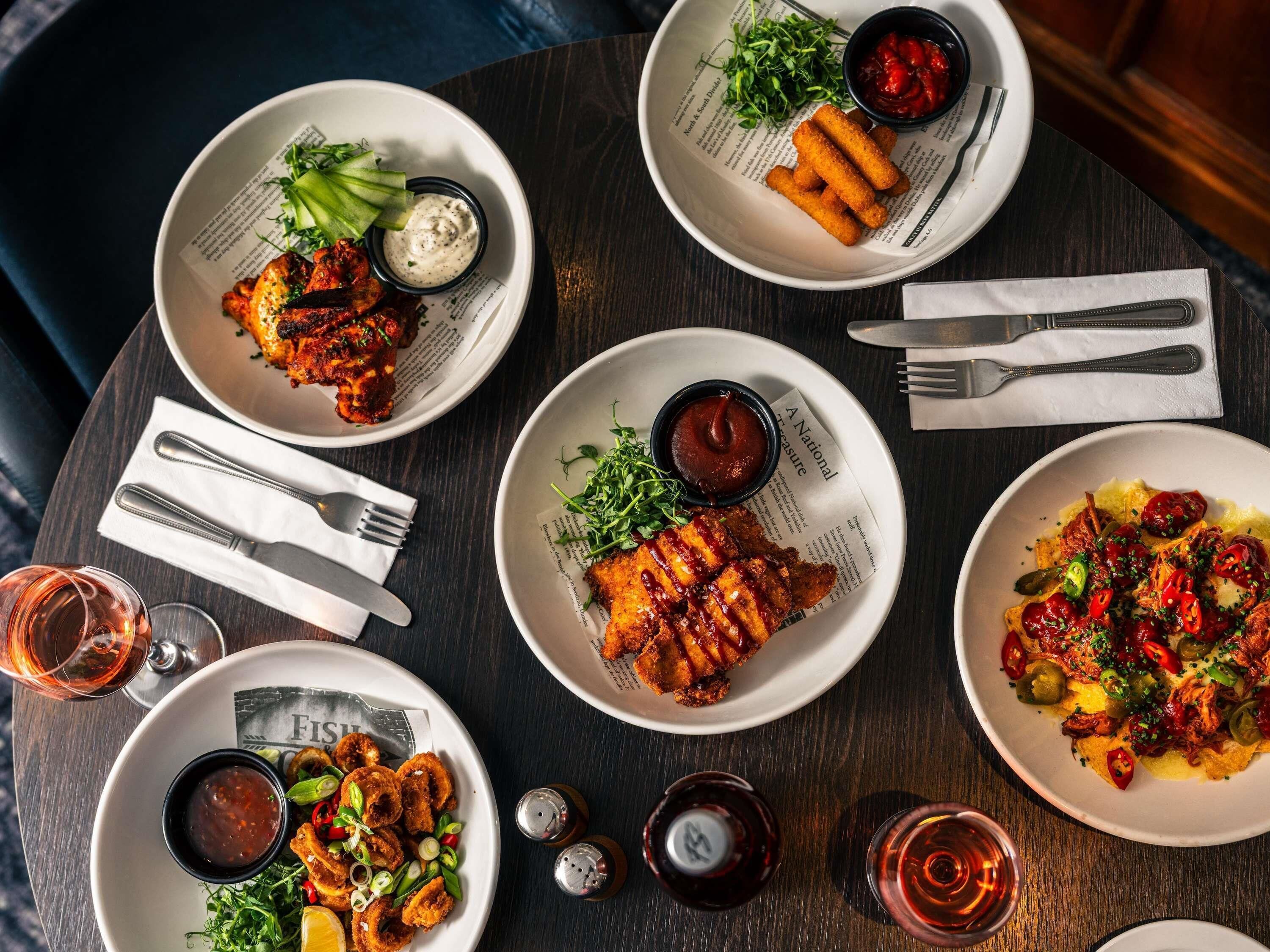 A table with various dishes, cutlery, and condiments.