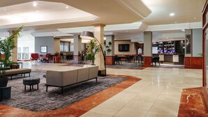 A spacious lobby with a seating area, a bar, and a television screen. - Mercure Daventry Court Hotel (Daventry)