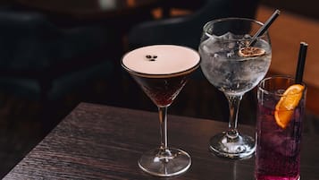 Trois verres sont posés sur une table dont le plateau est en bois foncé.