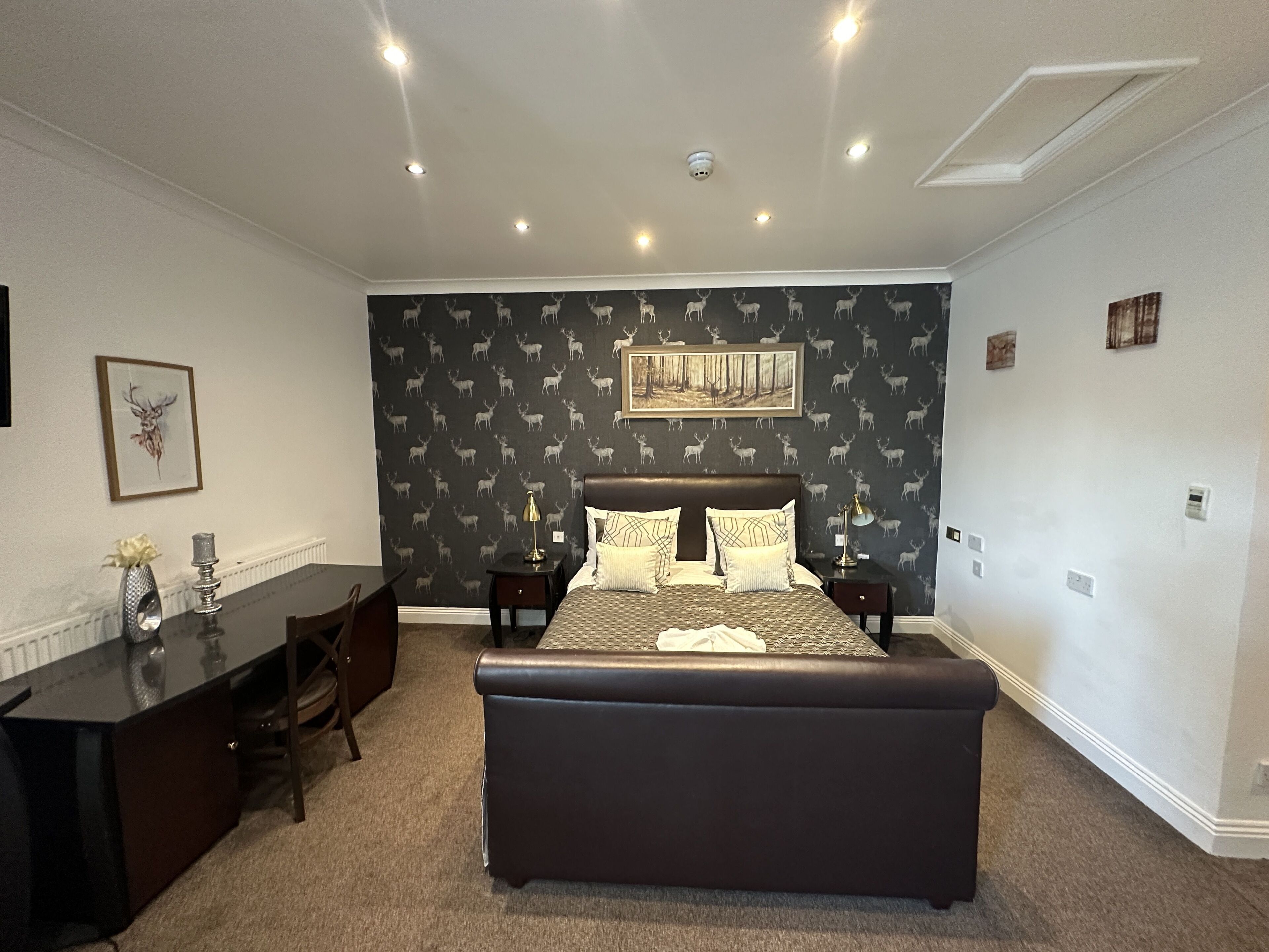 A bedroom with a large bed, a desk, and a chair.