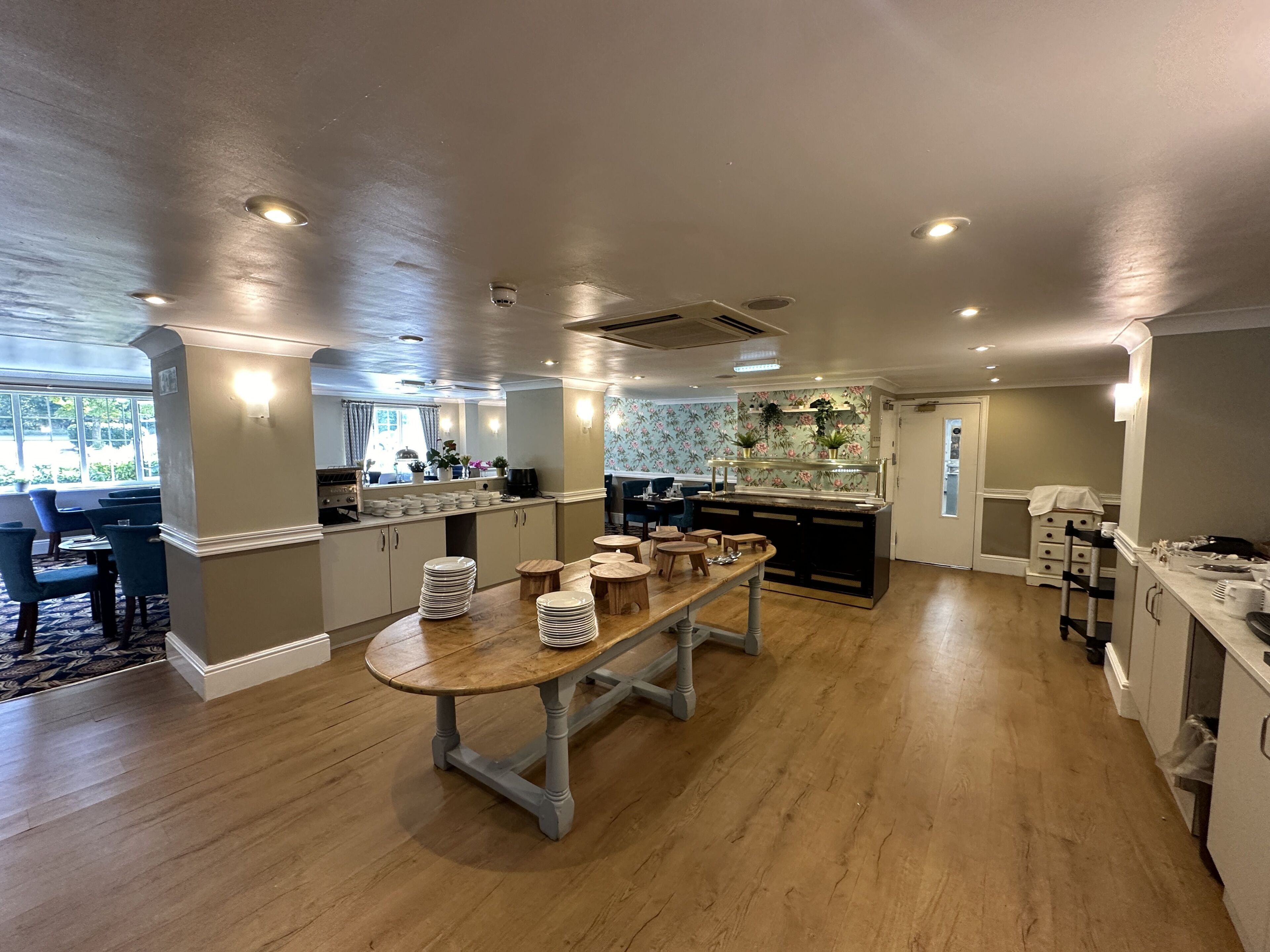 Una cocina amplia con una isla central, una mesa de comedor de madera y vistas al exterior.