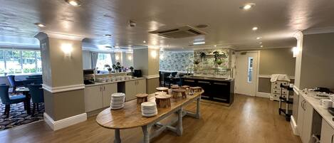Una cocina amplia con una isla central, una mesa de comedor de madera y vistas al exterior.