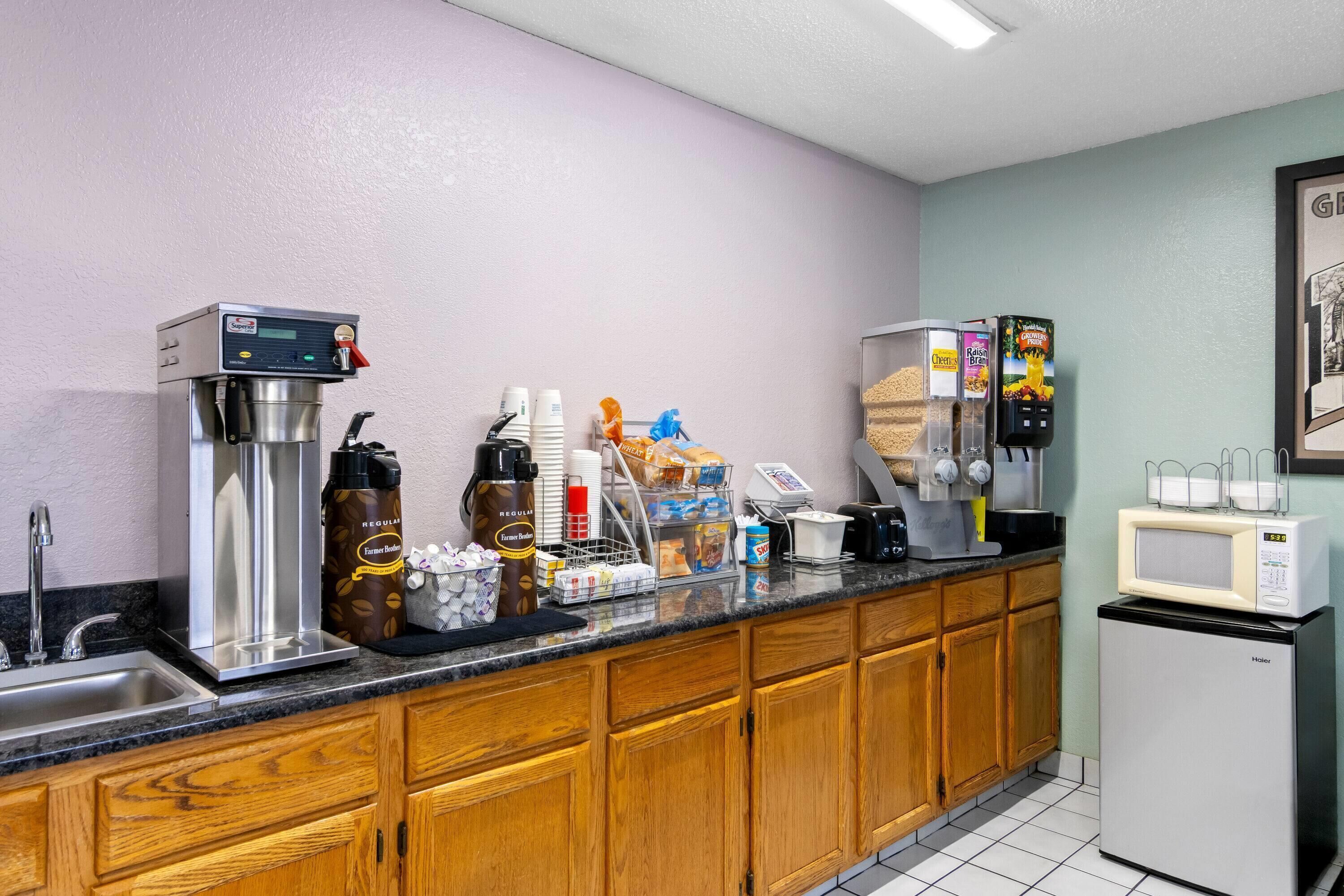 A kitchenette with a coffee machine, microwave, and refrigerator.