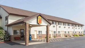 A Super 8 motel with a covered entrance, a parking lot, and a small garden area. - Super 8 by Wyndham Dixon (Dixon)