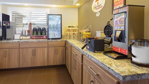 A breakfast area with a coffee machine, a refrigerator, and a menu board. - Super 8 by Wyndham Fortuna (Fortuna)
