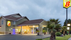 A Super 8 hotel with a covered entrance, outdoor seating area, and well-maintained landscaping. - Super 8 by Wyndham Fortuna (Fortuna)