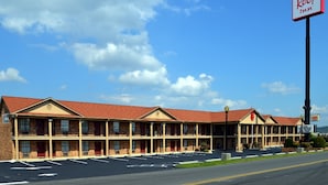 Een Red Roof Inn hotel met een gevel van baksteen, meerdere ramen en een parkeerplaats.