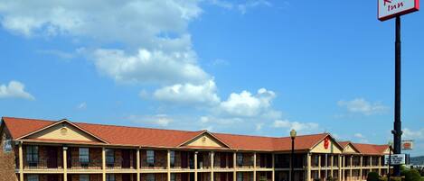 A Red Roof Inn with a brick facade, multiple windows, and a parking lot.