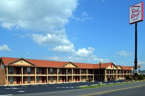 A Red Roof Inn with a brick facade, multiple windows, and a parking lot. - Red Roof Inn Cookeville - Tennessee Tech (Cookeville)