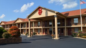 A motel with a central entrance, multiple balconies, and a flagpole. - Red Roof Inn Cookeville - Tennessee Tech (Cookeville)