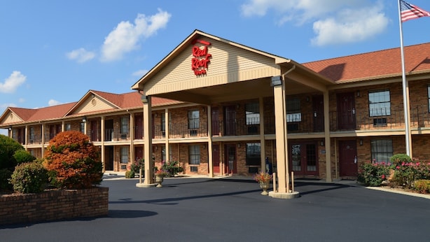 Een Red Roof Inn hotel met een gevel van baksteen, meerdere balkons en een parkeerplaats.