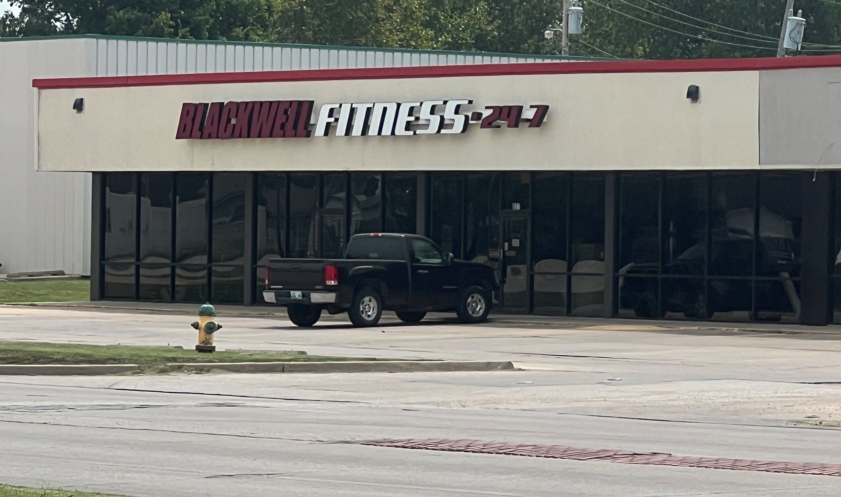 A building with a sign reading "BLACKWELL FITNESS-247".