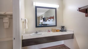 A bathroom with a sink, mirror, towel rack, and a towel hanging on the wall. - Super 8 by Wyndham Florence (Florence)