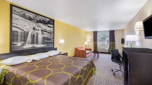 A hotel room with a large bed, a desk, a chair, a TV, and a painting of a waterfall on the wall. - Super 8 by Wyndham Florence (Florence)