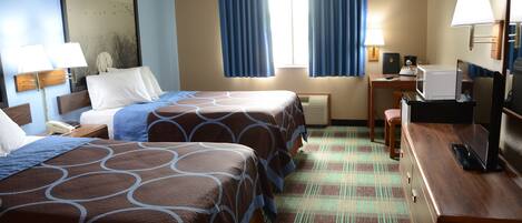 Une chambre d’hôtel avec deux lits, un bureau avec un ordinateur, un téléphone et une télévision.