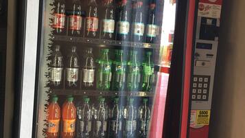 A Coca-Cola vending machine with a promotional sign for rewards.