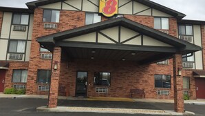 A Super 8 hotel with a brick facade, large windows, and a covered entrance.