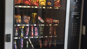 A vending machine stocked with various snacks and candies.