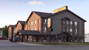 Un hotel con fachada de ladrillo, un acceso cubierto y un letrero que indica que es un Super 8.