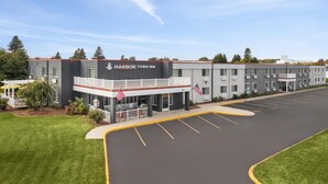 A multi-story hotel with a prominent entrance, a covered patio area, and a parking lot.
