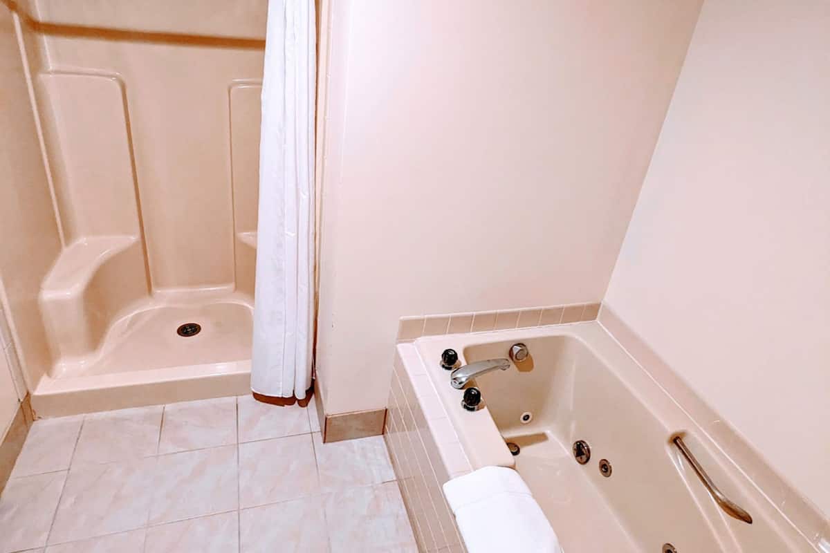 standard suite, 1 king bed | bathroom | deep-soaking bathtub, free toiletries, hair dryer, towels