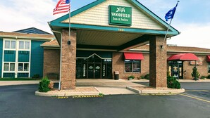 A Woodfield Inn & Suites building with a green roof, American flags, and a 'No Parking' sign. - Woodfield Inn and Suites (Marshfield)