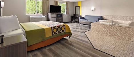 Ett hotellrum med en säng, ett skrivbord, en stol, en tv och ett badrum.