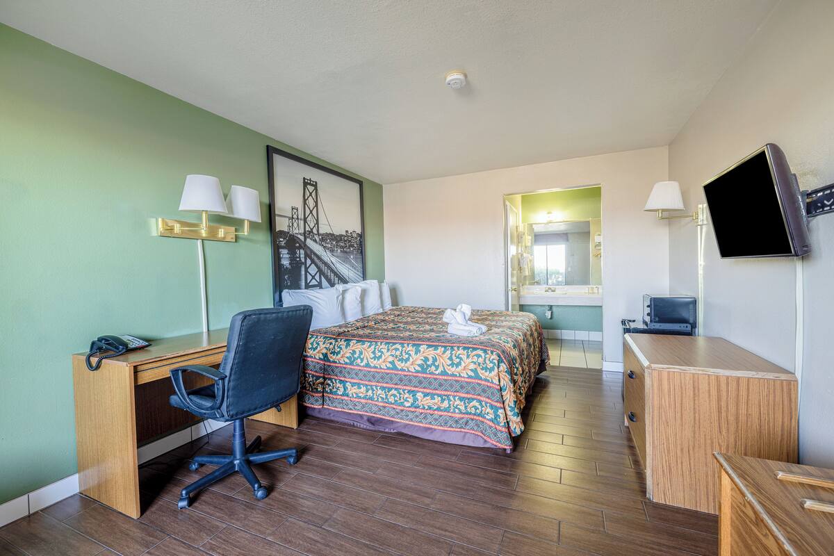 Une chambre d’hôtel équipée d’un lit, d’un bureau, d’une chaise et d’un téléviseur.