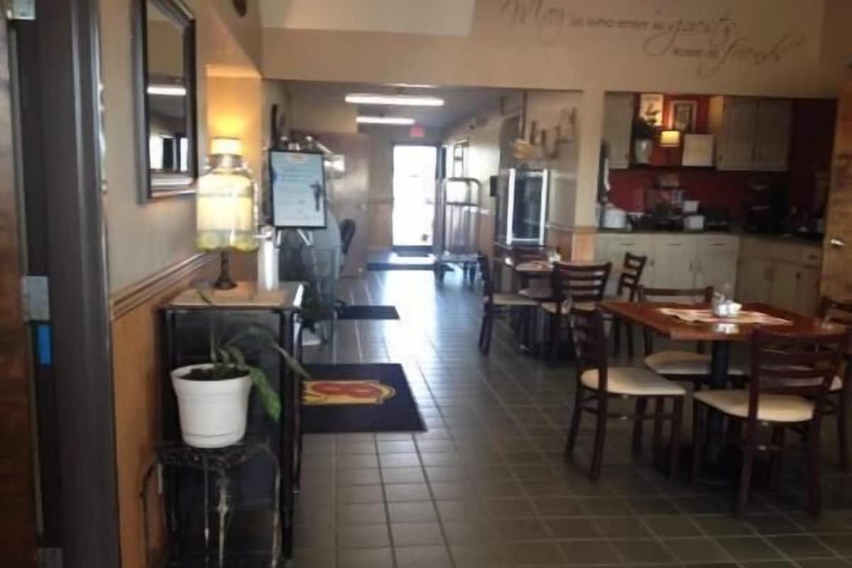 A hotel corridor with a dining area, a kitchen, and a reception desk.