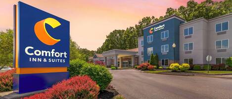 A Comfort Inn & Suites sign with a modern building in the background.