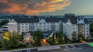 A multi-story hotel with a prominent sign, a parking lot, and a view of the city skyline. - Residence Inn by Marriott Toronto Markham (Markham)
