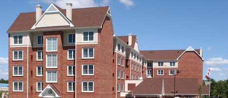 A multi-story brick building with a symmetrical facade, multiple windows, and a central entrance.