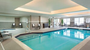 A swimming pool with lounge chairs and a reception desk. - Cambridge Suites Mississauga (Mississauga)