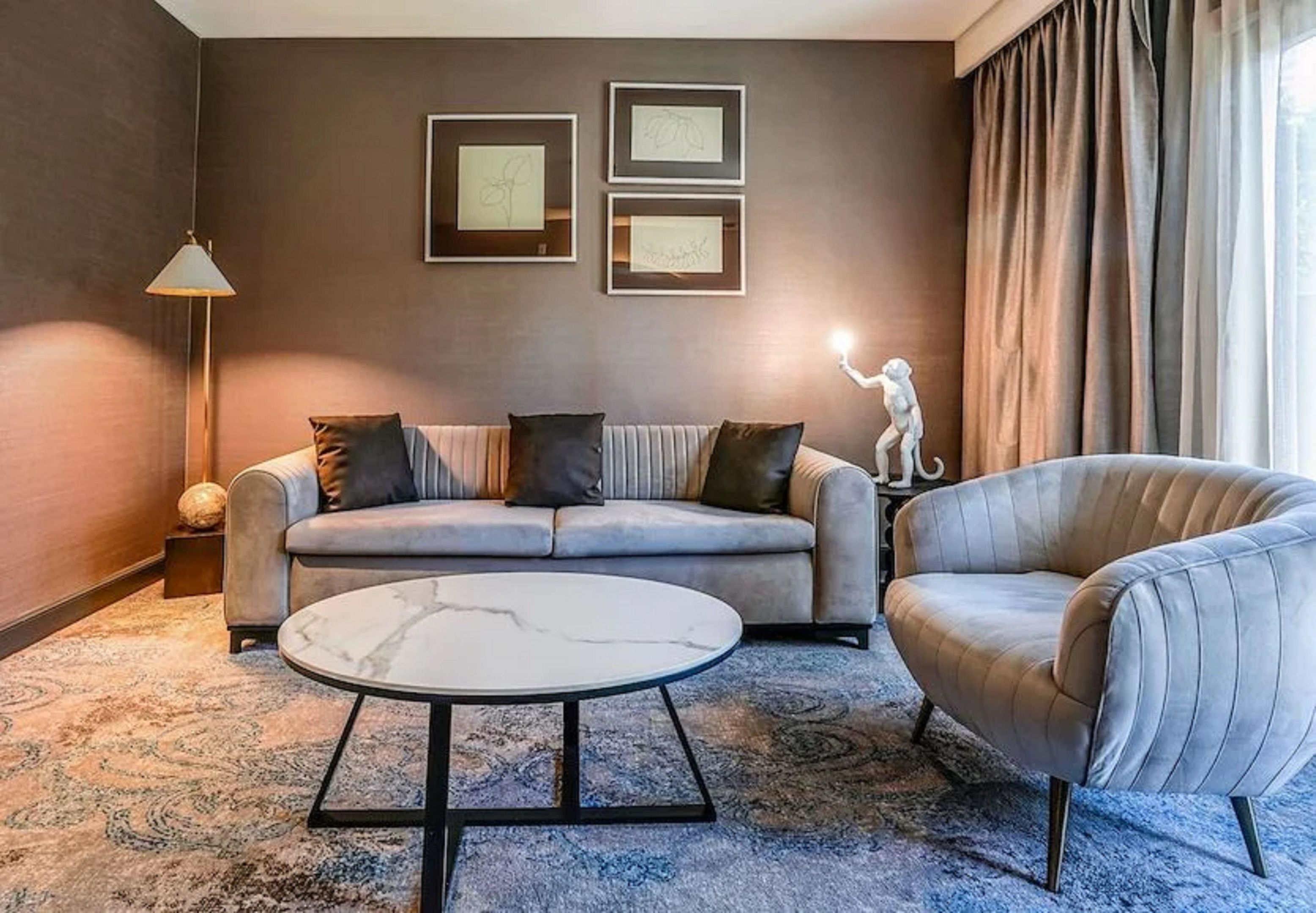 A modern living room with a sofa, armchair, and coffee table.