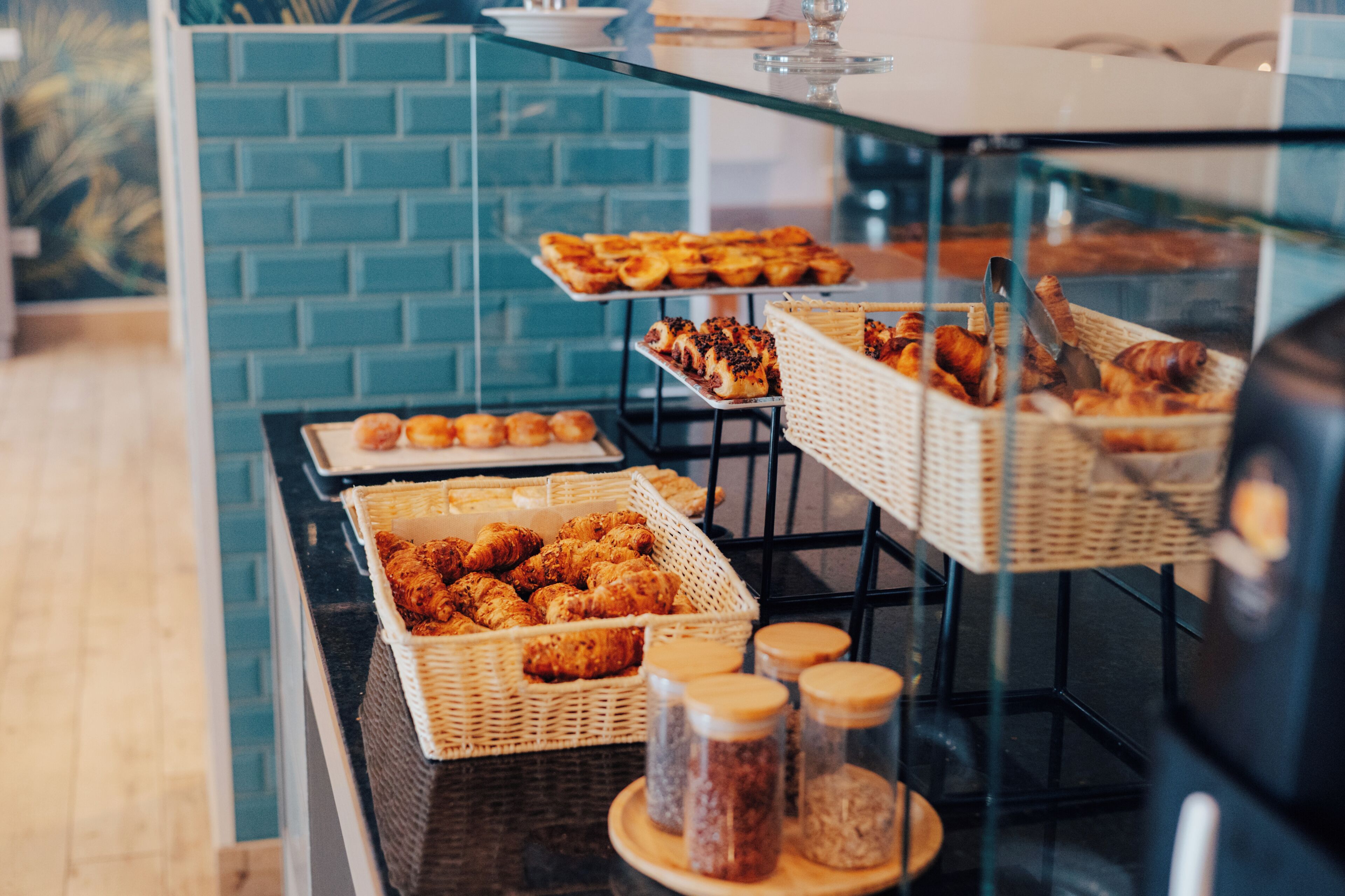 A buffet with various baked goods and jars of condiments.