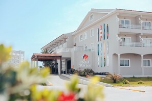 A hotel with a modern design, featuring a prominent logo and multiple windows.