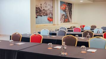 Ein Konferenzraum mit Tischen, Stühlen und Kunstwerken an den Wänden.