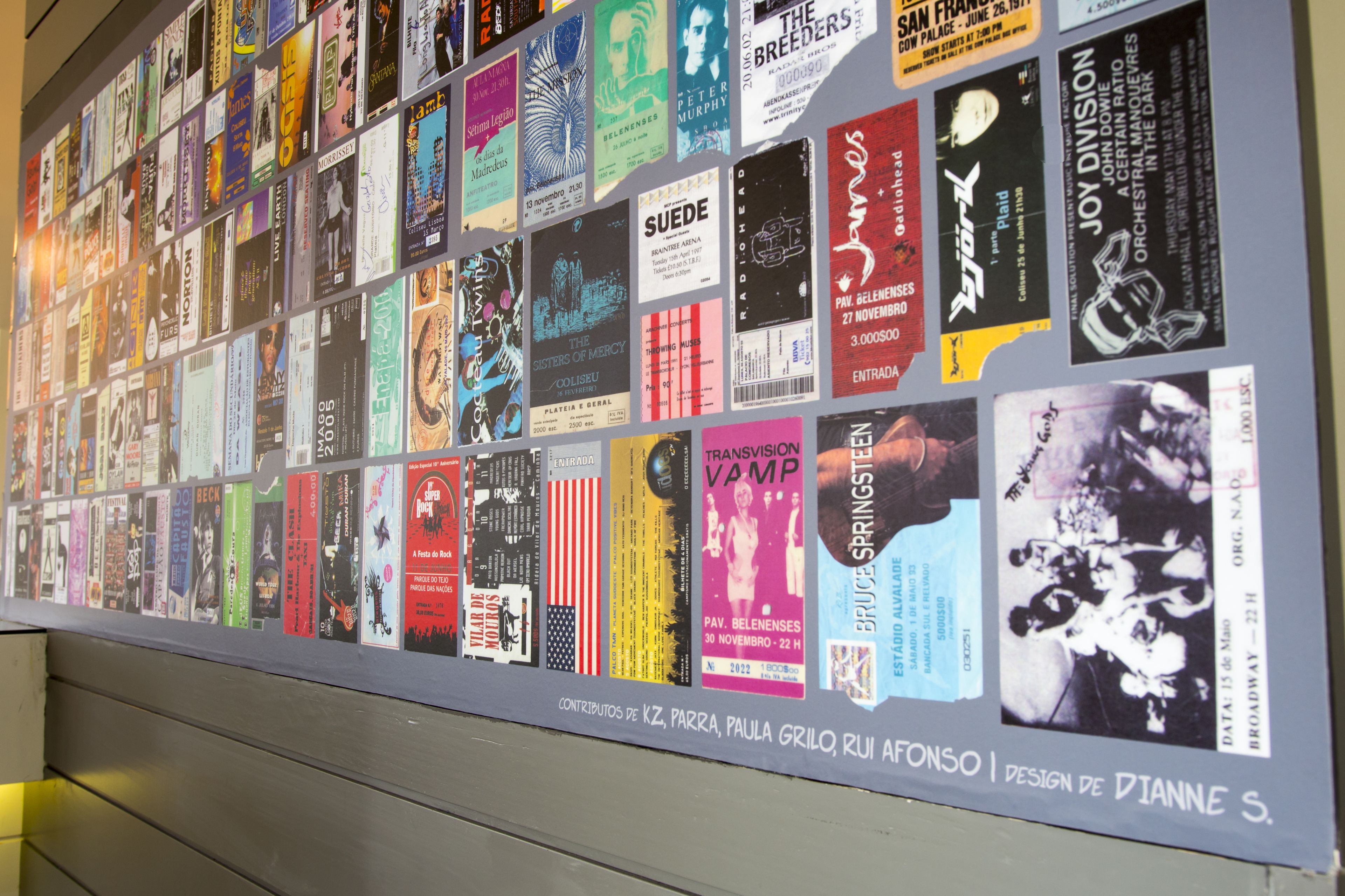 A wall with a collection of colorful posters and flyers.
