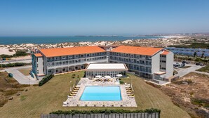 A hotel with a swimming pool, multiple balconies, and a view of the sea. - Star Inn Peniche (Peniche)