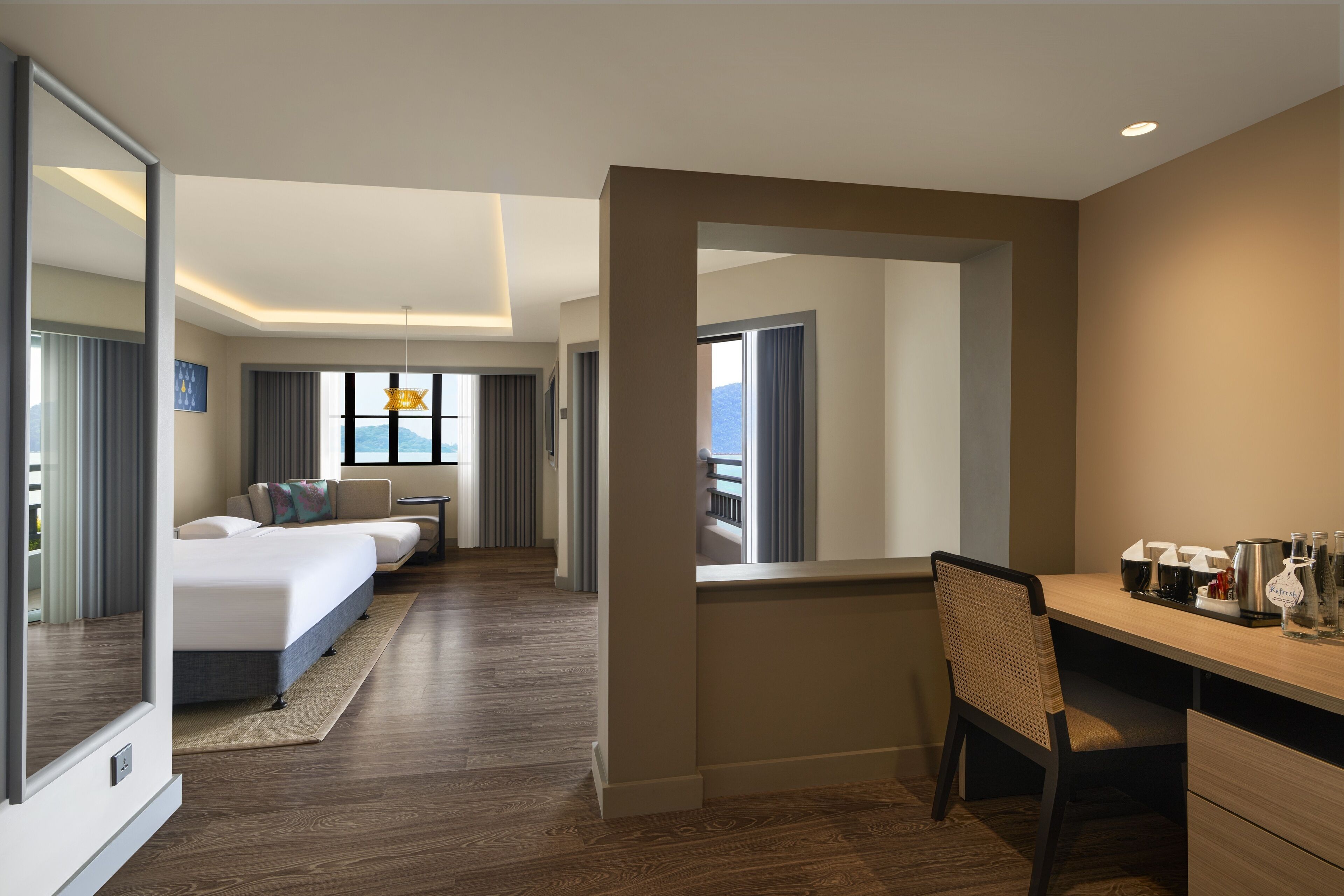 A hotel room with a bed, a desk, and a view of the mountains.