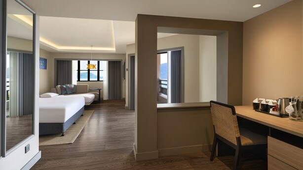Une chambre d’hôtel avec un lit, un bureau et une vue sur les montagnes.