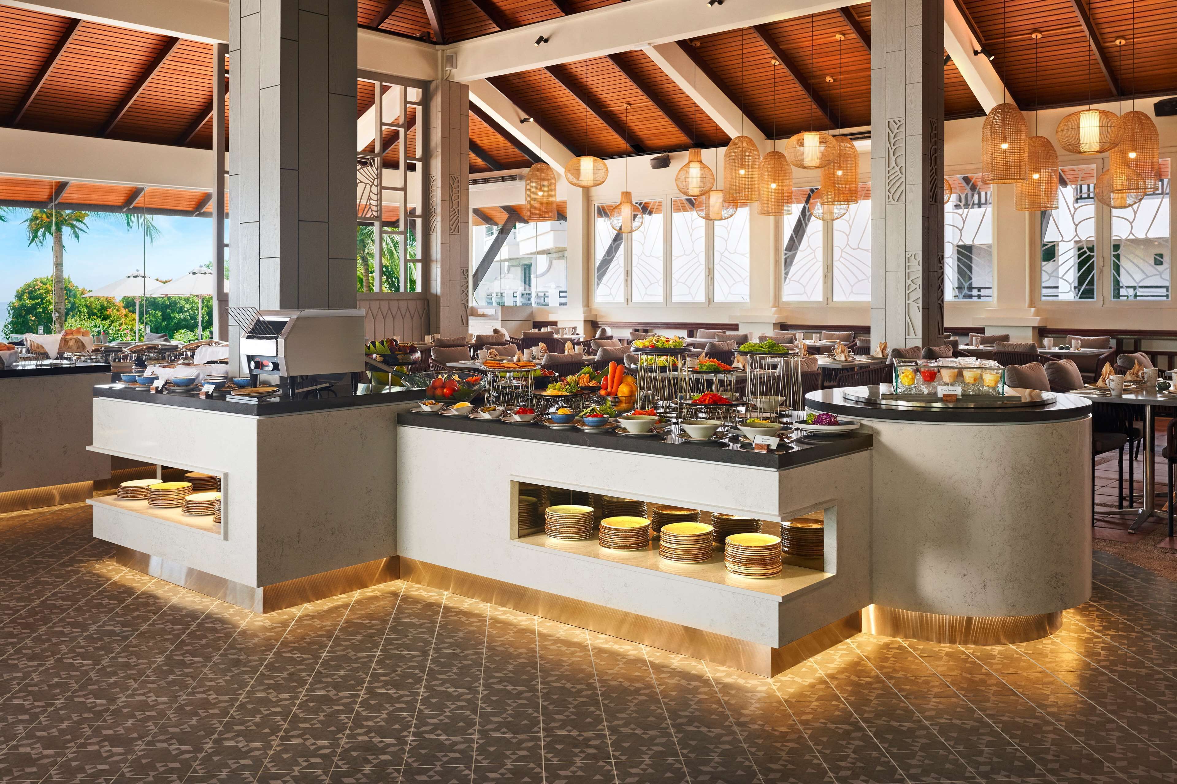 A buffet area with multiple serving stations, a variety of food items, and a modern interior design.
