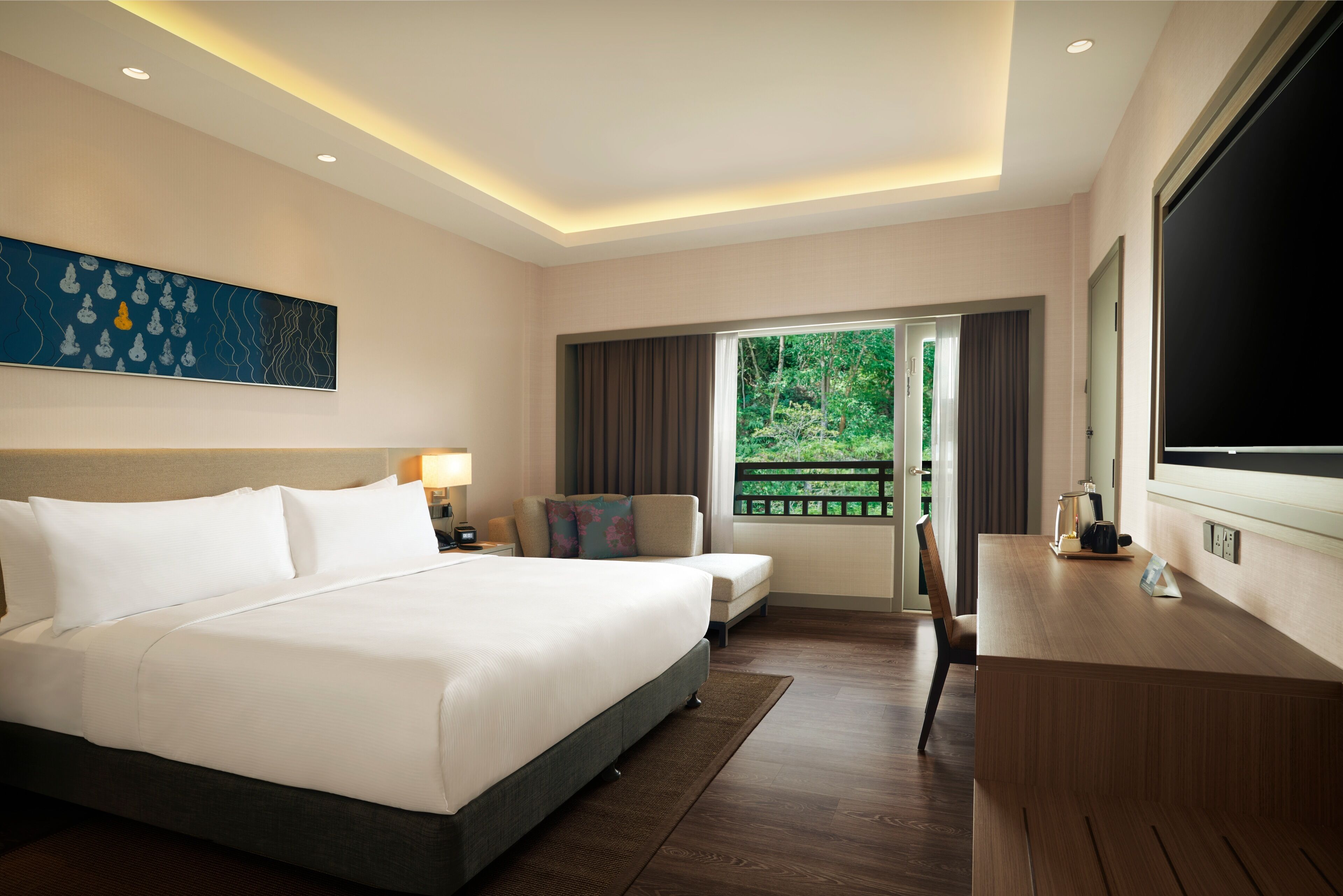Une chambre d’hôtel avec un grand lit, un bureau, une chaise, une télévision et une fenêtre donnant sur un paysage verdoyant.