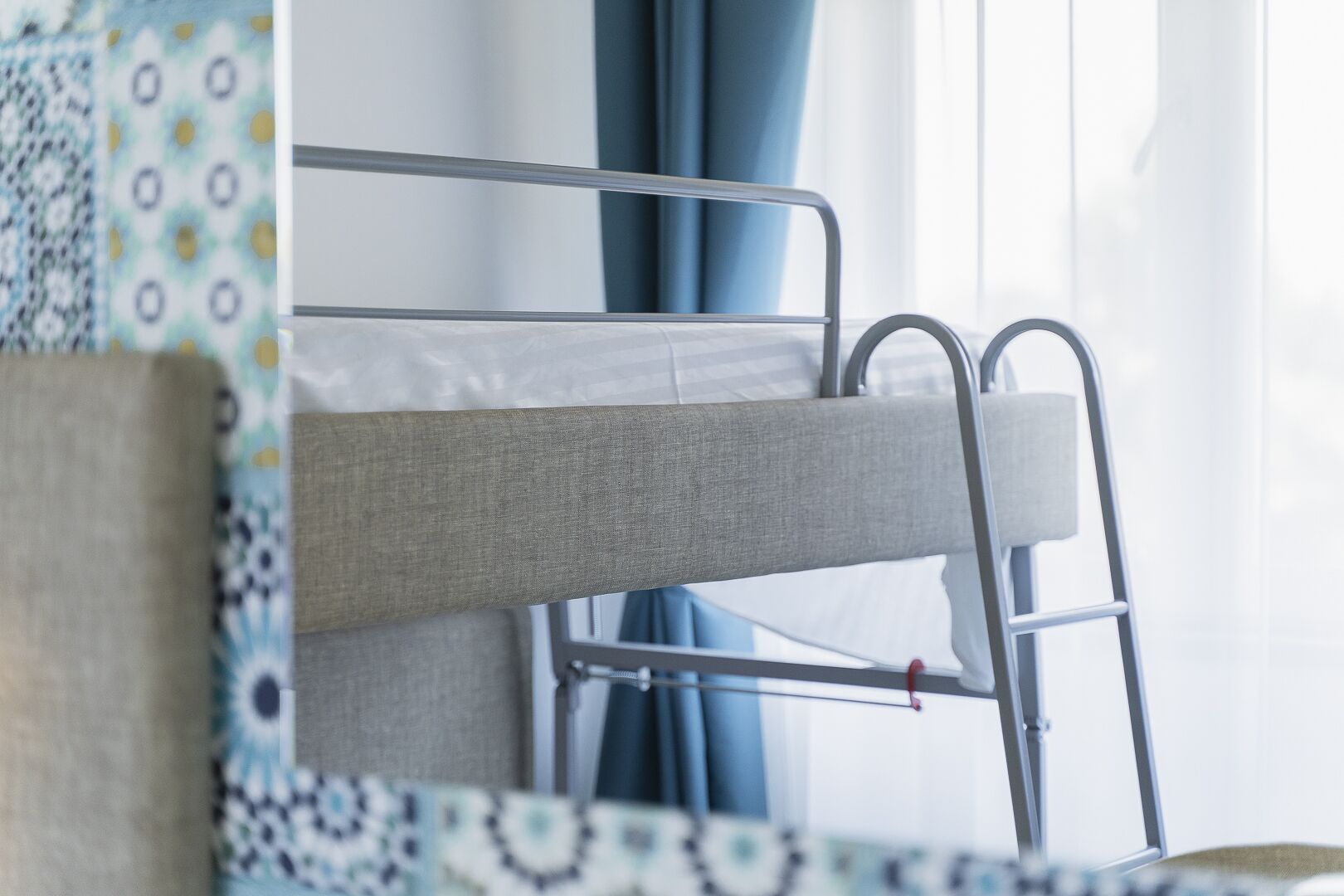 A bunk bed with metal railings and a grey mattress.