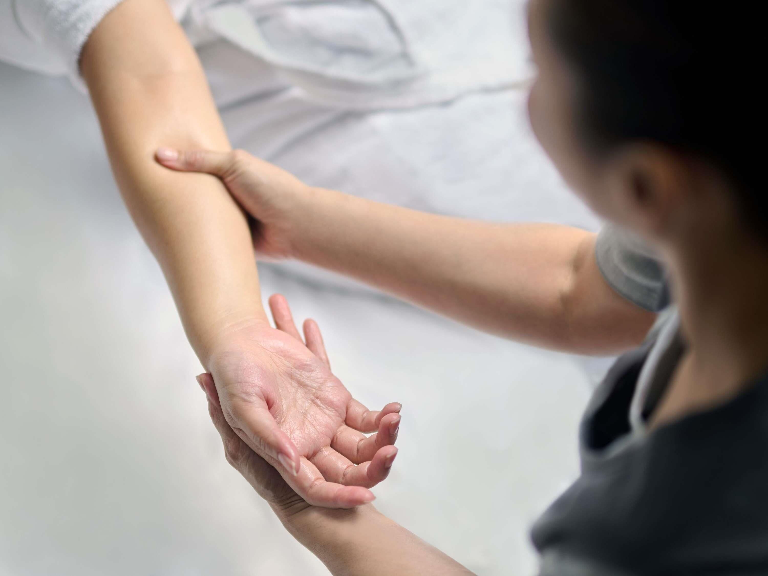 Una persona recibiendo un masaje en el brazo.