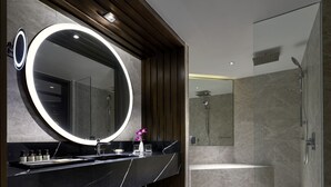 Une salle de bain moderne avec un grand miroir, un meuble-lavabo, une douche et une baignoire.