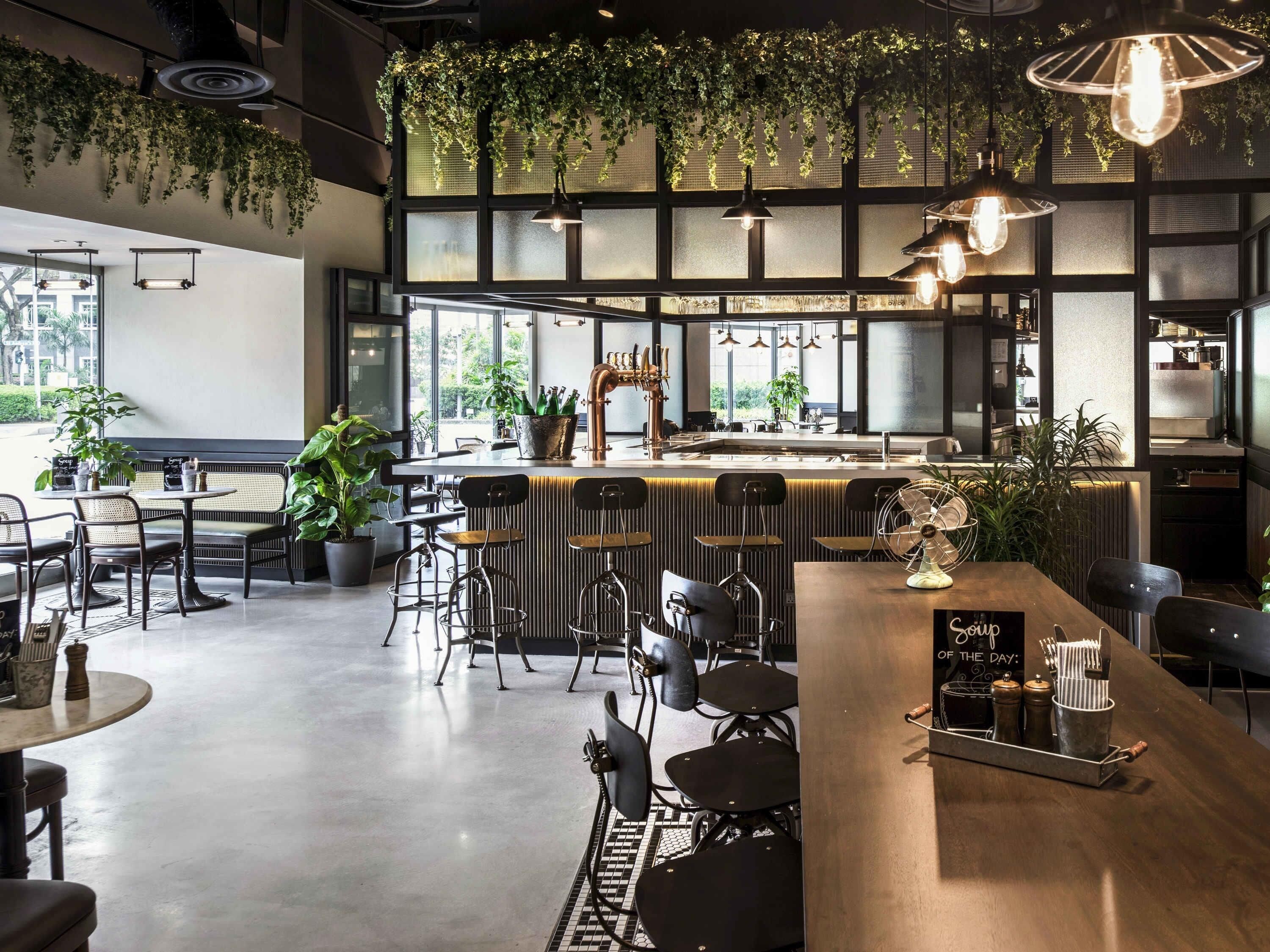 A modern cafe with a bar area, seating, and large windows.