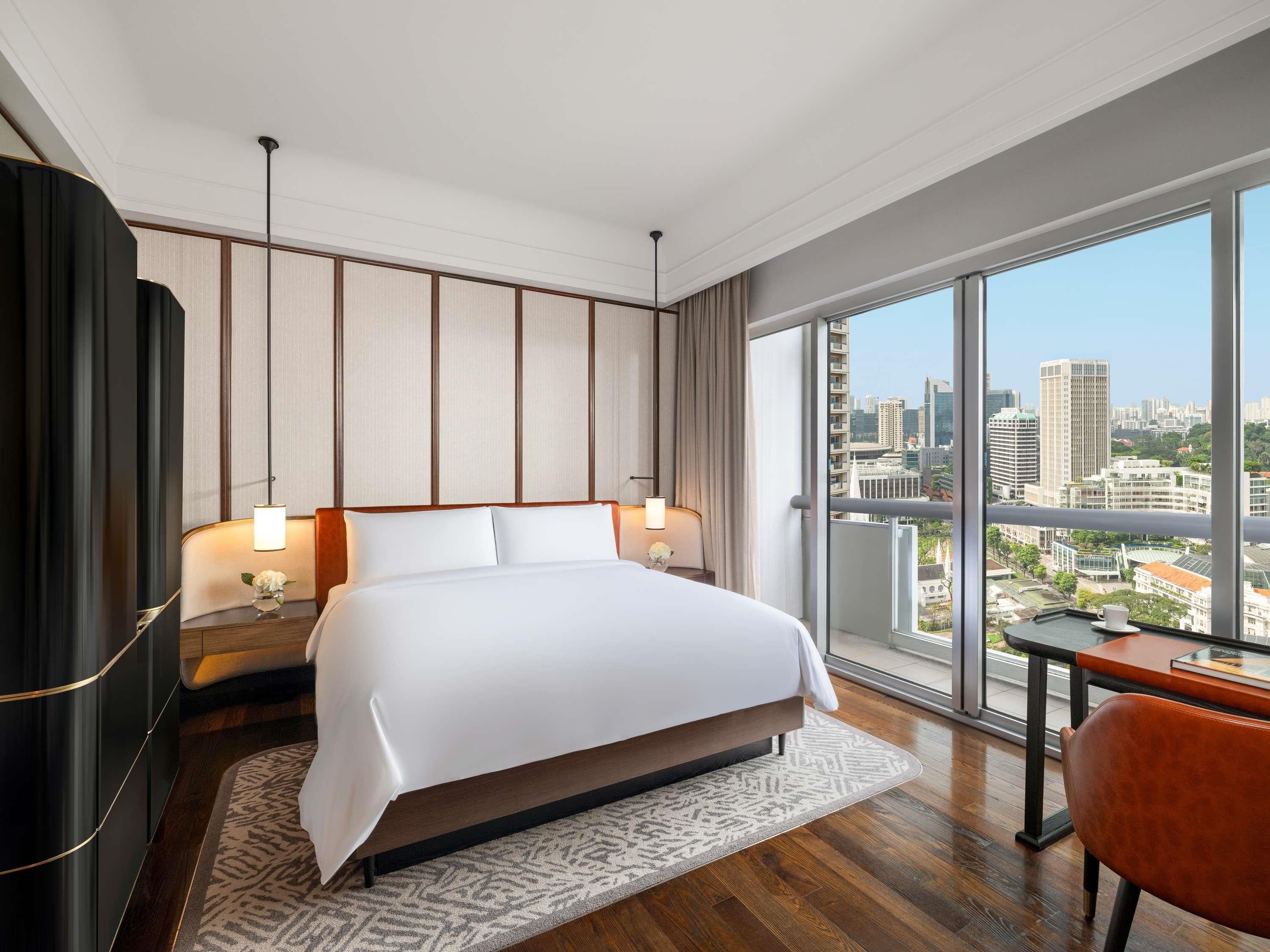 Un hotel moderno con una cama grande, un escritorio y vistas a la ciudad.