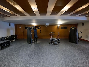 Un gimnasio con equipo de ejercicio, una barra de dominadas y una bicicleta estática.