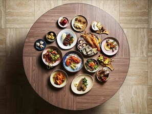 A round wooden table with various dishes and seafood. - Fairmont Singapore (Singapore)